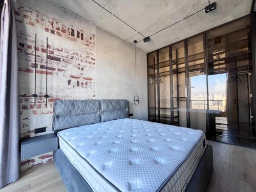 a bedroom with a bed and a large window at Designer View Vake in Itʼkhvisi