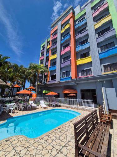 a hotel with a swimming pool in front of a building at Hotel Conexão in Penha