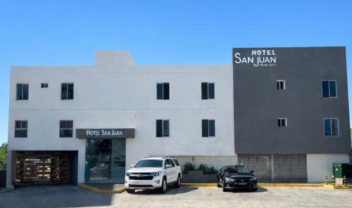 a white van parked in a parking lot in front of a building at Hotel San Juan Periferico in Villahermosa