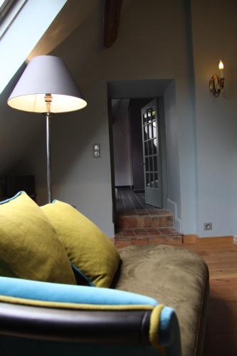 a living room with a couch and a lamp at L'Hibernie in Rochefort-en-Yvelines