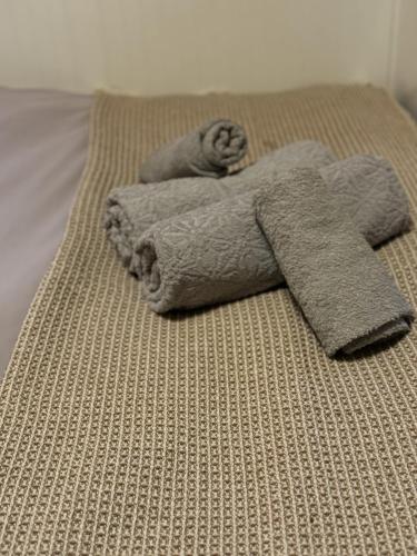a man laying on a bed with a pile of towels at Zimmer mit Balkon im Stuttgart Flughafen Messe in Ostfildern