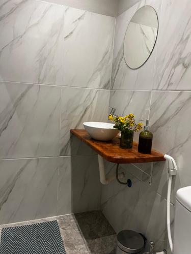 a bathroom with a sink and a mirror on a shelf at Casa verde in Fortim