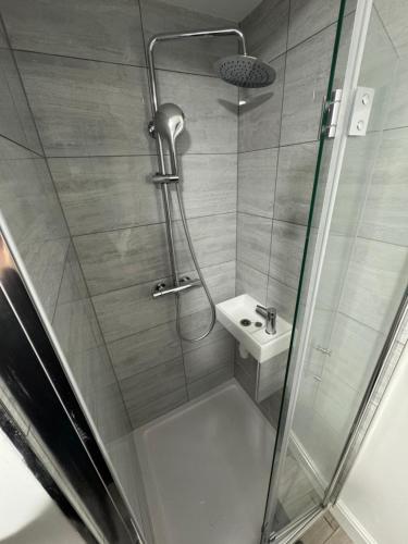 a bathroom with a shower and a sink at 96 Nelgarde Guesthouse in London
