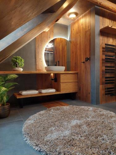 a bathroom with a sink and a large rug at Apartmány Wake up Coffee in Proseč