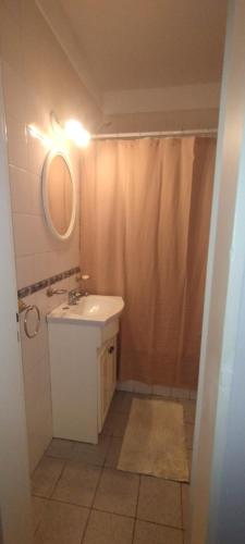 a bathroom with a sink and a shower with a mirror at Dpto del Cerro in Tandil
