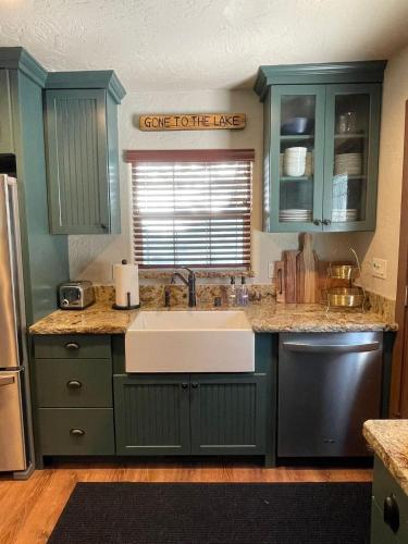 a kitchen with blue cabinets and a white sink at The Little Dipper Cabin in Shaver Lake