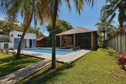 une cour avec une piscine et des palmiers dans l'établissement Milamar, à Iztapa