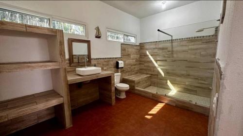 une salle de bains avec douche, lavabo et toilettes dans l'établissement Milamar, à Iztapa
