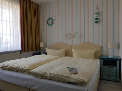 a bedroom with a large bed with a clock on the wall at Landhotel Ostseetraum & Apartments in Warnemünde
