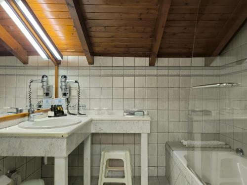 a bathroom with a sink and a bath tub at Hotel Europa Olympia in Olympia