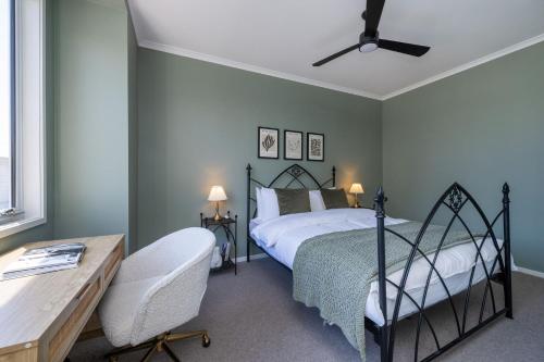 a bedroom with a bed and a desk at Evergreen by the Bay in Sandringham