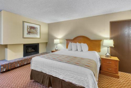 a hotel room with a large bed and a fireplace at SureStay Plus Hotel by Best Western Reno Airport in Reno