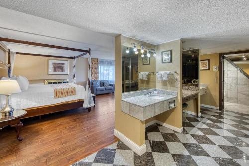 a hotel room with a bed and a large bathroom at SureStay Plus Hotel by Best Western Reno Airport in Reno