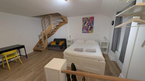 a small bedroom with a bed and a staircase at Le refuge bellifontain in Fontainebleau