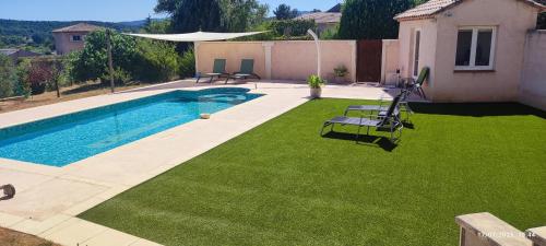 un jardin avec piscine et pelouse verte dans l'établissement La Picholine du Val, à Le Val
