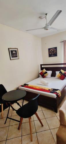 a bedroom with a bed and a chair and a couch at Shanzu Studio Stamford Apartment in Mombasa