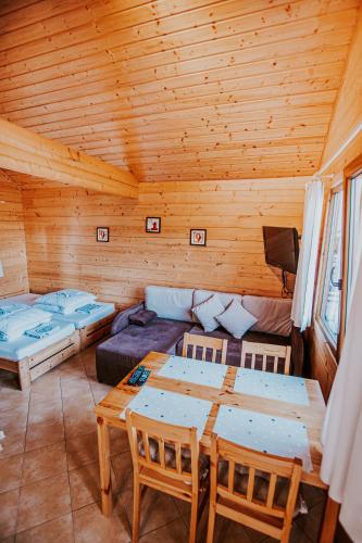 a room with two beds and a table and chairs at Domki Heaven Ustronie Morskie in Ustronie Morskie