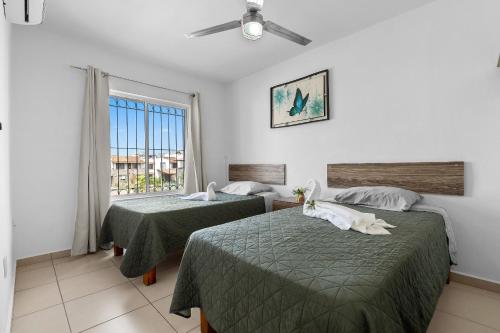 a hotel room with two beds and a window at Modern Pool Side, 3 Bdrm House with parking in Puerto Vallarta