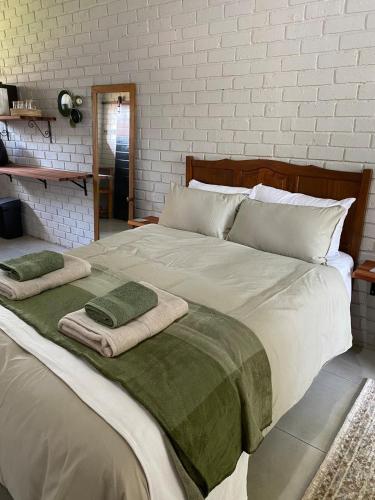 a large bed with two towels on top of it at The Cozy Acre Unit 2 in Potchefstroom