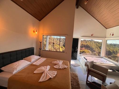 a bedroom with a bed and a tub in a room at Chalé Bella Vista 03 in Água Boa