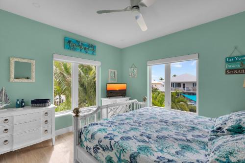 a bedroom with blue walls and a bed and a window at Casa Mar in Islamorada