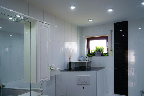a white bathroom with a shower and a sink at Zimmer mit Balkon im Stuttgart Flughafen Messe in Ostfildern