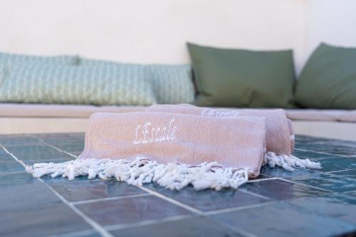 a pink towel sitting on a tiled floor with a couch at L'Escale - Une parenthèse en duo in Châteauneuf-du-Pape