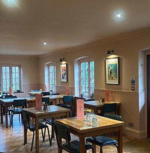 a restaurant with wooden tables and chairs and windows at The Mooring Post in Gloucester