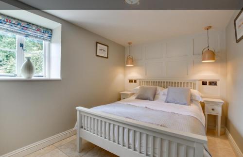 a bedroom with a white bed and a window at Snettisham Watermill Pet Friendly Historic Listed Property in Snettisham