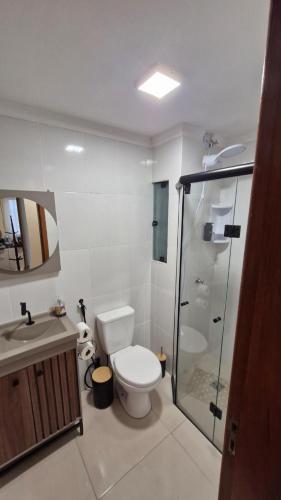 a bathroom with a toilet and a sink and a shower at Apartamento inteiro in Ponta Grossa