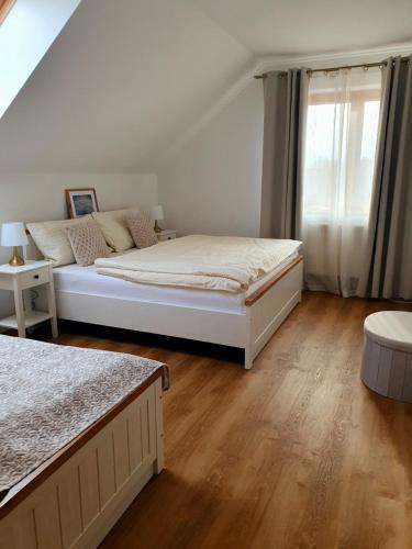 a bedroom with a bed and a window at Penzion Apartmány Libošovice in Libošovice