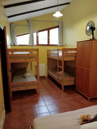 a room with three bunk beds in a room at Caserío Areitz Soroa in Arce
