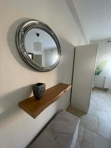 a mirror on a wall with a wooden shelf at Apartment Akanthous in Kallithea Halkidikis
