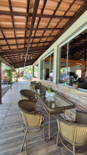 a patio with a table and chairs on a porch at Sítio no Rio de Janeiro, privativo, Natureza, conforto e lazer em Nova Iguaçu, RJ in Nova Iguaçu