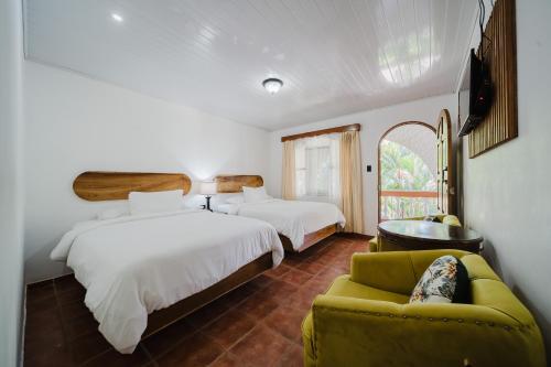 a hotel room with two beds and a couch at Hotel Villabosque Eco Boutique in Manuel Antonio