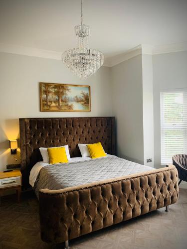 a bedroom with a large bed with yellow pillows at The Gungate Hotel - Cocktails and Wine Bar in Tamworth