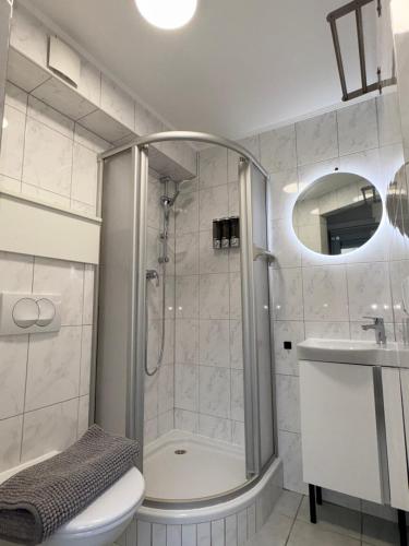 a bathroom with a shower and a toilet and a sink at Apartment Café Ettelbrück in Ettelbruck