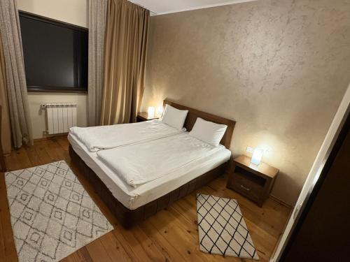 a small bedroom with a bed and a television at Hotel Smilen in Smolyan