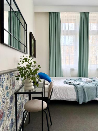 a bedroom with a bed and a table with a chair at Expo Śniadeckich in Poznań