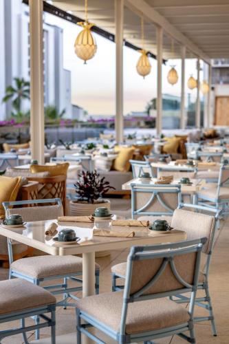a row of tables and chairs in a restaurant at Ka Laʻi Waikiki Beach, LXR Hotels & Resorts in Honolulu