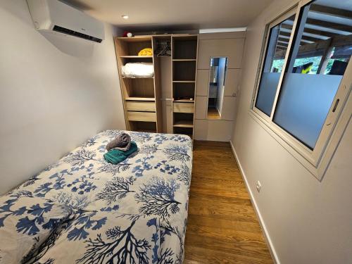 a bedroom with a bed with a blue and white blanket at Contain'House Paradise in Les Abymes
