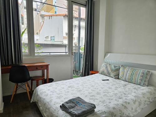 a bedroom with a bed and a desk and a window at LoCo Fully Equipped House - 2BR3WS in Ho Chi Minh City