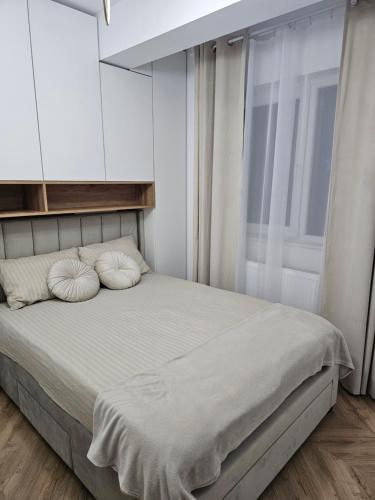 a bedroom with a bed with two pillows on it at Urusagului flat in Floreşti