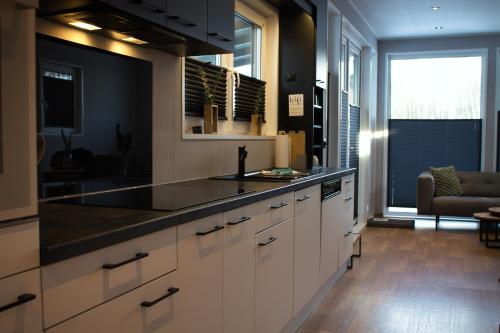 a kitchen with white cabinets and a black counter top at Ferienhaus Aurora in Twist