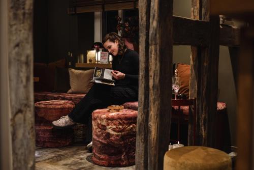a man sitting on a couch reading a book at Landgasthaus & Hotel zur Krone in Dahn