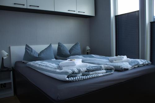 a bed with blue sheets and pillows on it at Ferienhaus Aurora in Twist