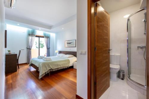 a bedroom with a bed and a bathroom with a shower at Luz Beach Luxury Apartment in Luz