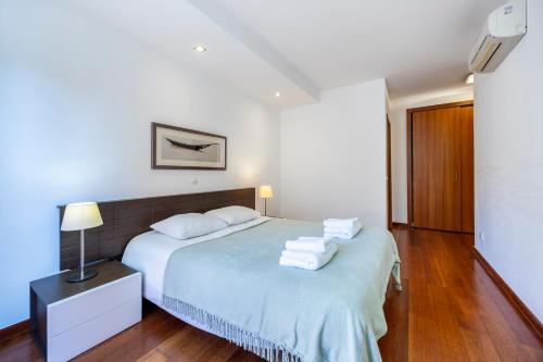 a bedroom with a bed with towels on it at Luz Beach Luxury Apartment in Luz