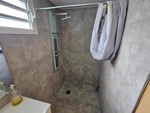 a bathroom with a shower with a white robe at Contain'House Paradise in Les Abymes