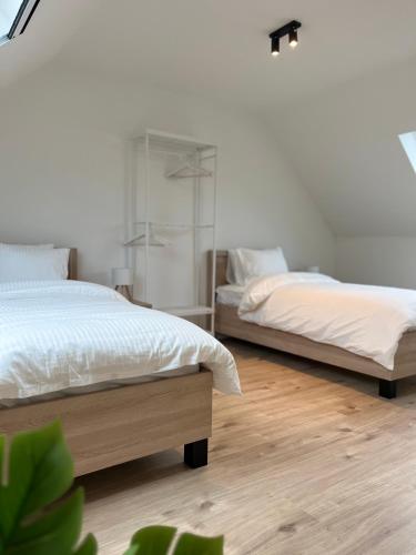 two beds in a bedroom with wooden floors at FDS Luxe House in Ghent